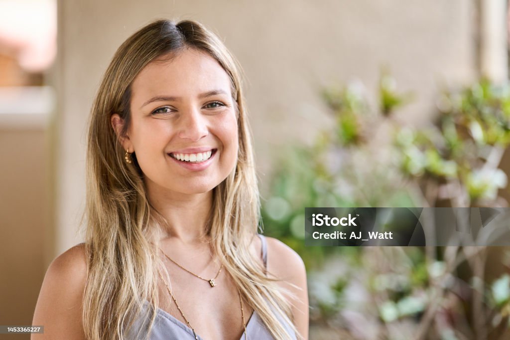 Young female architect standing in her office and smiling Portrait of a young female architect standing alone in a bright modern office and smiling Smiling Stock Photo