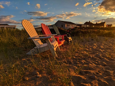 Red white and blue Adirondack chairs at Cape Cod Beach at Sunset