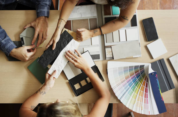 interior designer discussing tile and color options with clients in her office - decorando imagens e fotografias de stock