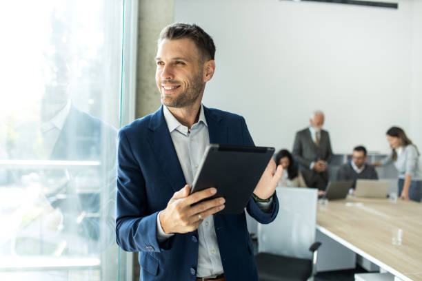 Cheerful caucasian young businessman freelancer using digital tablet inside modern office