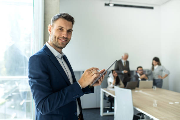 istock Cheerful caucasian young businessman freelancer using digital tablet inside modern office 1453369236