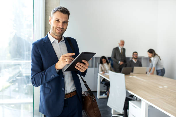 istock Cheerful caucasian young businessman freelancer using digital tablet inside modern office 1453369320