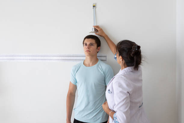 nutrizionista e deportologa che misura l'altezza del paziente adolescente durante la consultazione medica - metro per laltezza foto e immagini stock