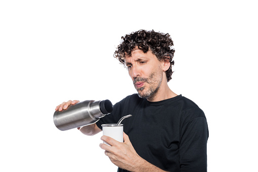 Middle aged man priming mate with thermos, isolated on white background.