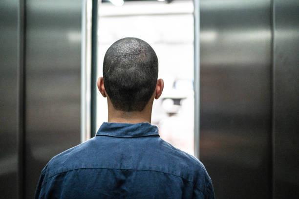 Visually impaired man waiting the elevator door opening