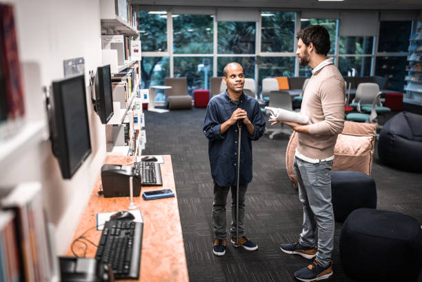 istock Mid adult man visually impaired talking with friend at university 1453374376