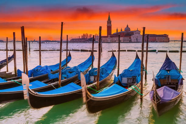 View on gondolas in Venice Gondolas in Venice at red sunrise campanile venice stock pictures, royalty-free photos & images