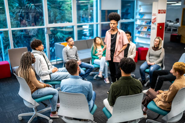 istock Mid adult man standing talking to students at university 1453374599