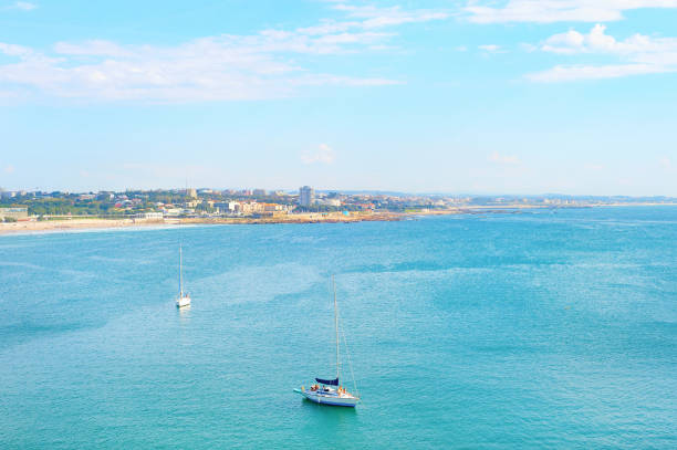 Sailing yacht by Atlantic ocean coast,  sunny waterfront of Matosinhos, aerial view from Leixoes port cruise terminal, Porto, Portugal