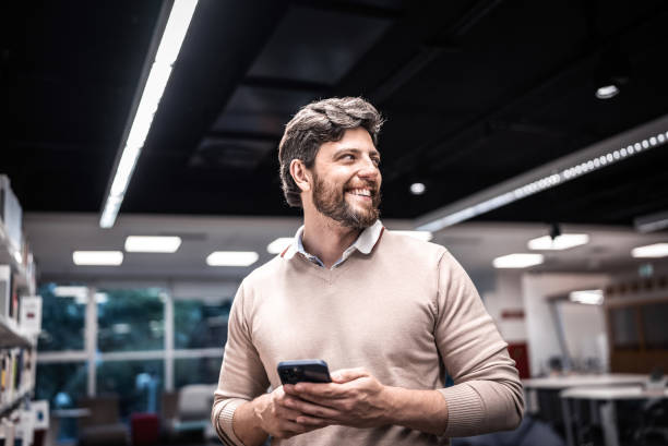istock Mid adult man using mobile phone at university 1453375496