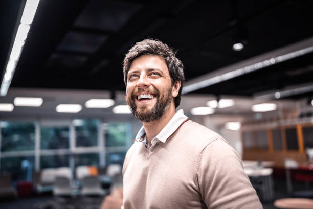 Mid adult man looking away contemplating at library