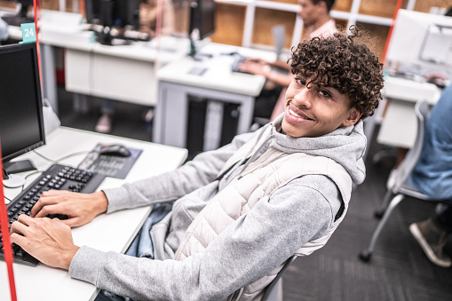 Portrait of university student working on computer in the library at campus