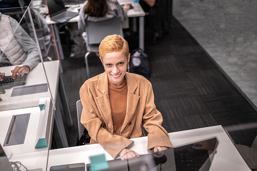 Portrait of university student working on computer in the library at campus