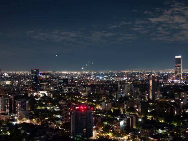 istock Mexico city skyline at night with airplane light trails 1453380612