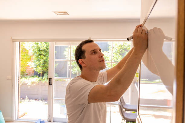 istock Happy man at home writing on drawing board 1453382907