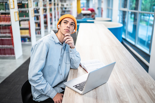 Young student man contemplating in university library