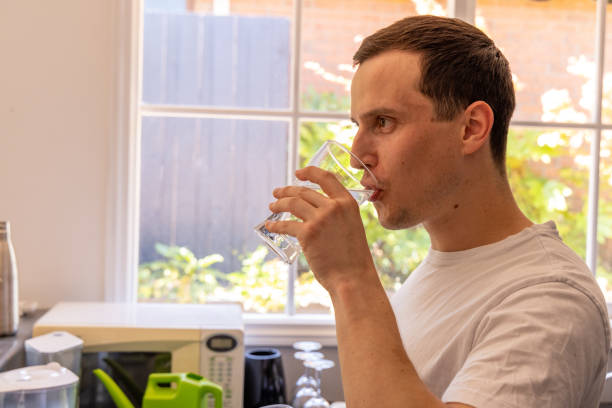istock Happy man at home drinking water in the kitchen 1453383943