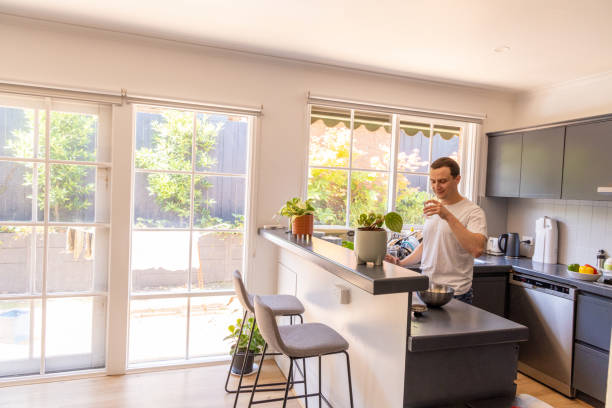 istock Happy man at home drinking water in the kitchen 1453384013