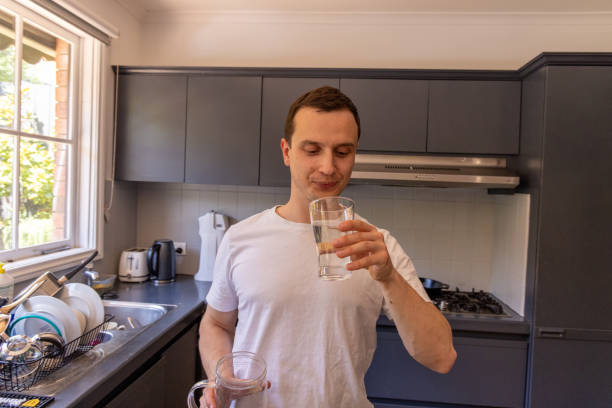 istock Happy man at home drinking water in the kitchen 1453384034