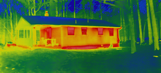 Exterior of a house taken with a heat-sensing camera showing higher amounts of heat emitted in the brighter parts.