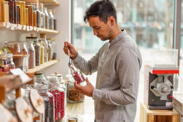 istock Male Costumer Refilling A Reusable Jar In A Sustainable Store 1453388447