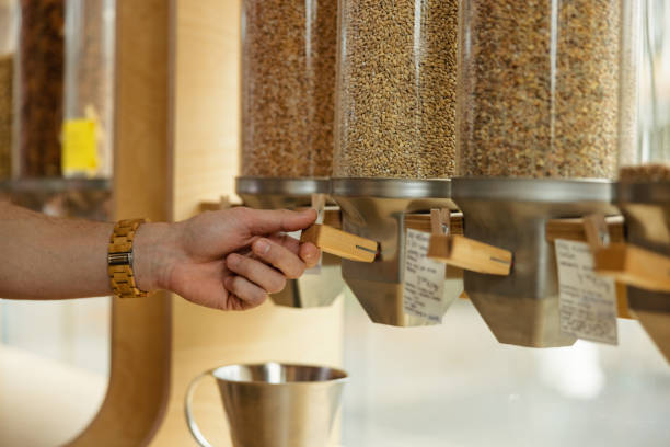 istock Close Up Of A Male Using A Cereal Dispenser In A Zero Waste Store 1453388460