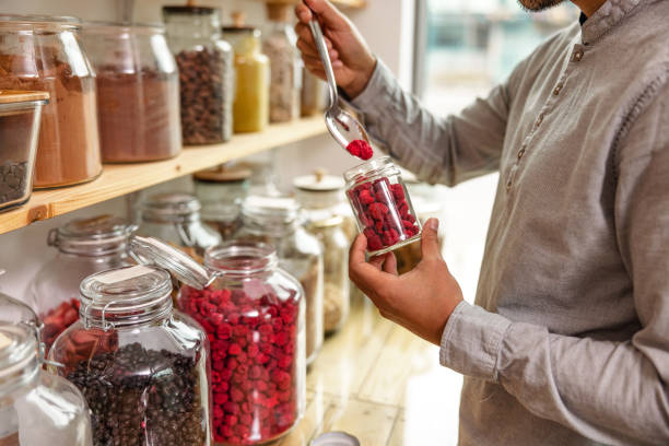 istock Close Up Of A Male Costumer Refilling A Reusable Jar In A Zero Waste Store 1453388471