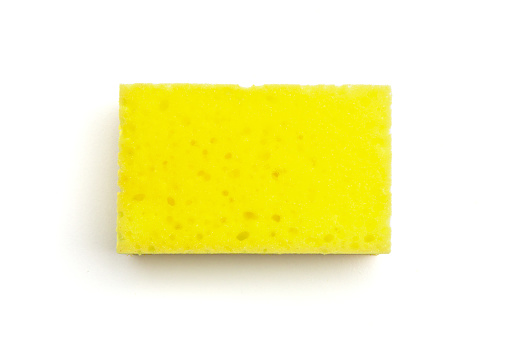 Single yellow kitchen sponge isolated on white background, closeup top view