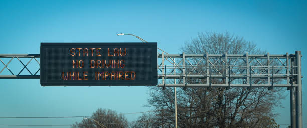 State Law: No Driving While Impaired An overhead highway sign reminds drivers that driving while impaired is illegal. driving under the influence stock pictures, royalty-free photos & images