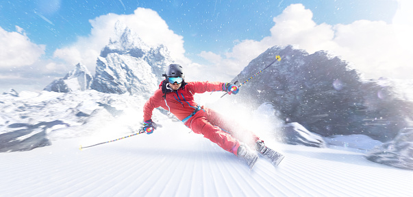 Rapid descent at high speed. Skier skiing on a sunny day in high mountains. Downhill. Ski skiing in mountains. Skiing descent at high speed. Snow dust. Sport