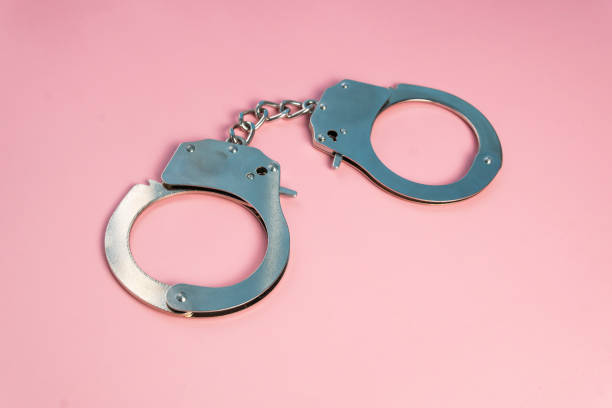 istock metal closed handcuffs on a pink background 1453407424