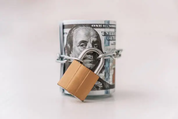 Photo of money dollars in a chain with lock on the background of white. The concept of banning dollars. the concept of keeping or banning cash dollars. money is banned.