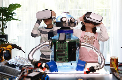 Genius  children wearing virtual reality glasses (VR) learning robot. Science technology class, Robotics and education,school children students build robotic, and programing control the Robot arm.