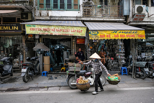 Hanoi, Vietnam - December 9, 2022: A street vendor selling food on a street in the Old Quarter of Hanoi in Vietnam.
