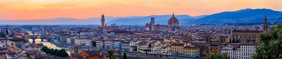 Panorama of Duomo Santa Maria del Fiore cathedral, Bell Tower of Giotto and Palazzo Vecchio Tower in Florence, Italy in a colorful sunset, aerial view