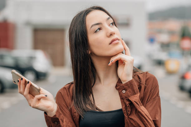 girl with mobile phone with expression of thinking or doubt