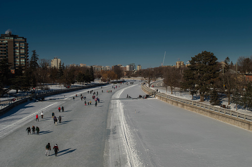 a high angle shot of people walking on snow covered field during daytime