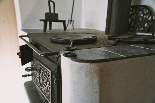 A closeup side view of an antique iron cooking oven