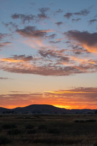 istock Beautiful shot of an orange sunset over mountains and fields 1453422878