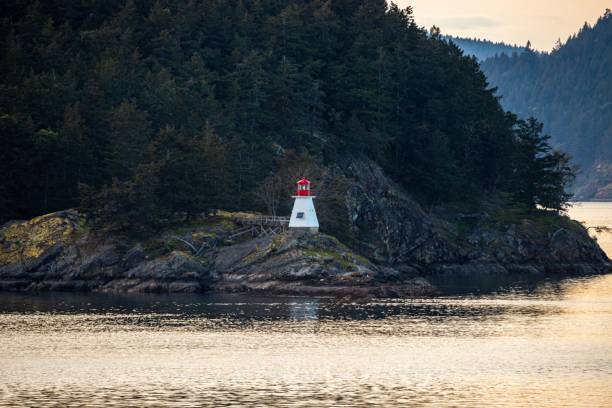 istock Lighthouse on a rocky cliff near the ocean 1453424428