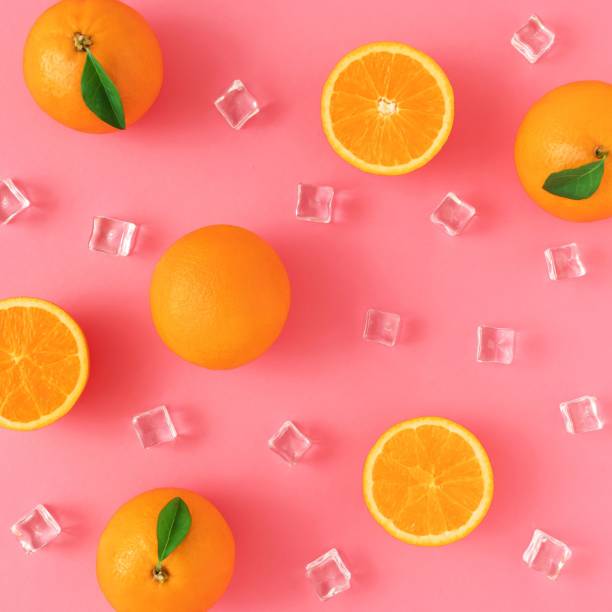 istock Creative summer pattern made of oranges and ice cubes on a pink background. 1453425384