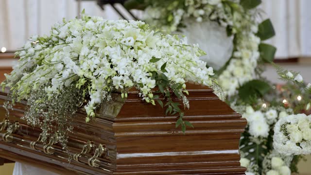Closeup of a casket with fresh white flowers during the Vietnamese funeral ceremony in 4K
