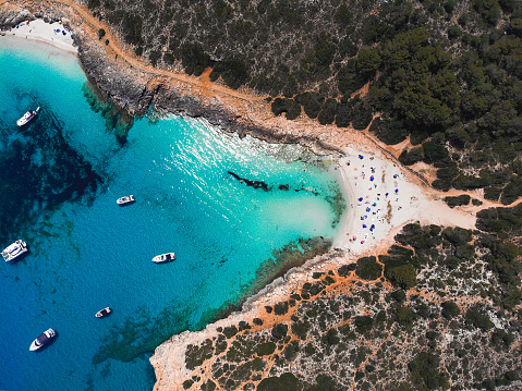 A beautiful drone view of the beach Cala Varques with boats on Mallorca