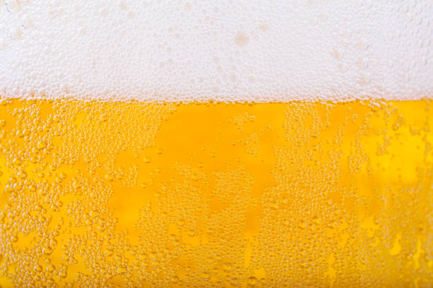 colpo ravvicinato di birra e sfondo schiuma bianca - bitter beer bottle alcohol beer foto e immagini stock