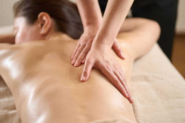 femme recevant un massage du dos au salon de beauté - shiatsu photos et images de collection