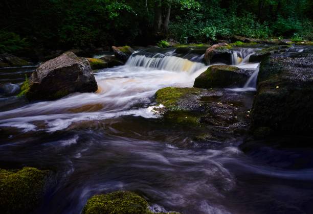 istock Light exposure stream of water over rocks 1453433129