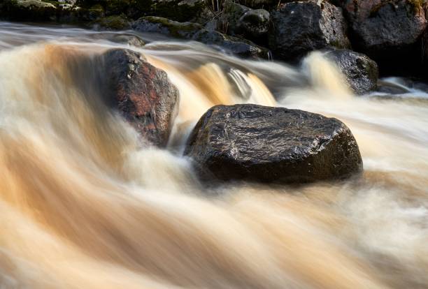 istock Light exposure stream of water over rocks 1453433144
