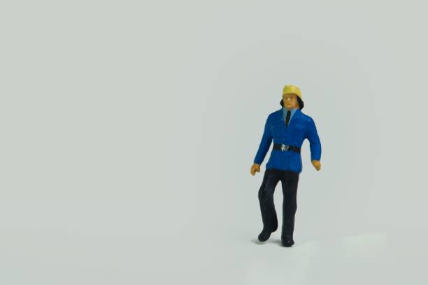 istock Miniature figure of a fireman standing on a white background 1453435341