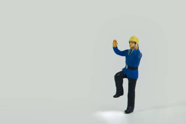istock Miniature figure of a fireman standing on one leg on a white background 1453435352