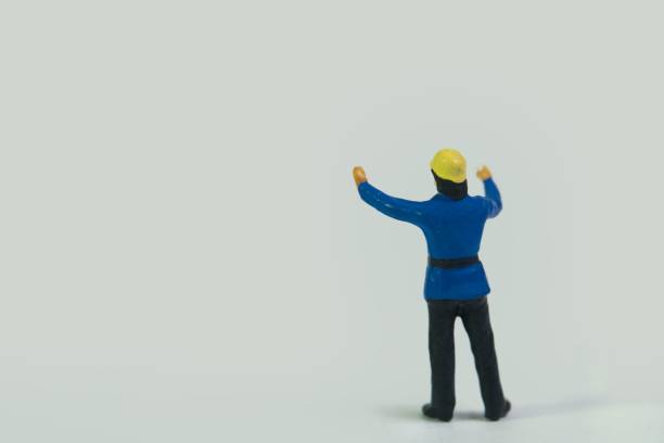 istock Miniature figure of a fireman standing on a white background 1453435354